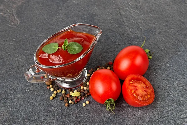 glass sauce-boat. gravy boat. tomato sauce on a black background