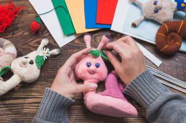 El yapımı hediyeler. El yapımı oyuncaklar. Tığ işi. Ahşap arka planda örme salyangozlar.