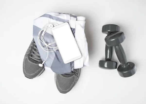 Des trucs sportifs et un faux téléphone portable. Gym trucs, téléphone portable et espace vide pour le plan d'exercice. Images De Stock Libres De Droits