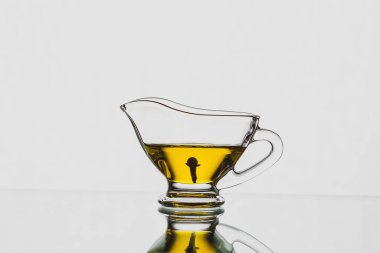 Beyaz arka planda cam sosta karanfil yağı. Baharat sos kabında karanfil olur.