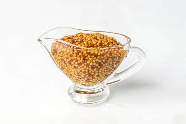 French mustard in a glass sauceboat on a white background. Dijon mustard Royalty Free Stock Images