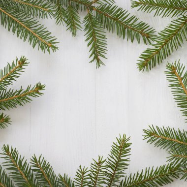 Beyaz ahşap arka grubunda köknar ağacı dalları olan Noel dekoru