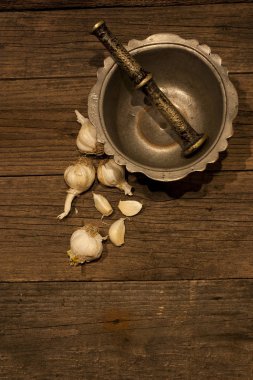 Bronz harç ve eski ahşap sarımsak karanfil ile havaneli. Kapat şunu. Vintage. Solucan ışığı. 