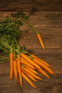 Eski ahşap zemin üzerine yeşil yaprakları ile taze havuç 