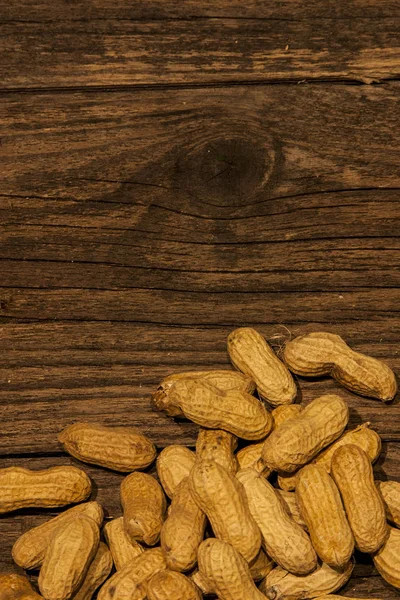 Peanuts, shell, old wood plot, vegan food, nuts close-up, less light.