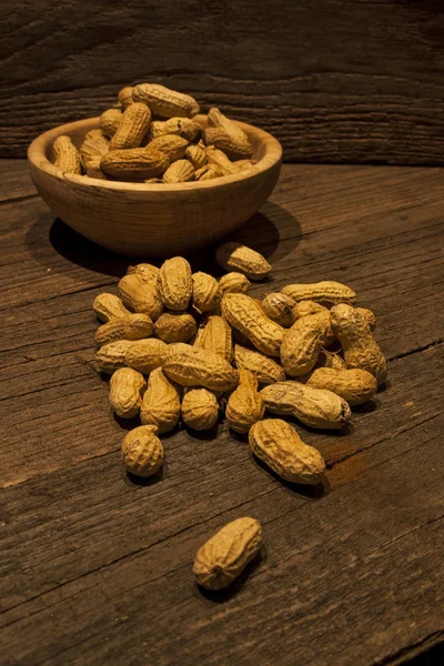 Peanuts, shell, old wood plot, vegan food, nuts close-up, less light.