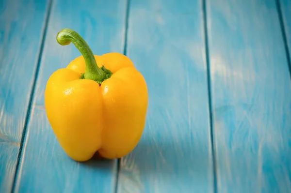 Sweet yellow pepper on blue wood kitchen table — Stock Photo, Image