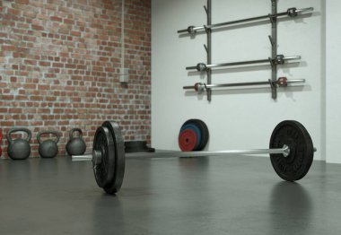 Bir spor salonu zemin üzerinde siyah plakalı halter