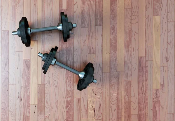 Dumbbell with black plates on a gym floor — Stock Photo, Image