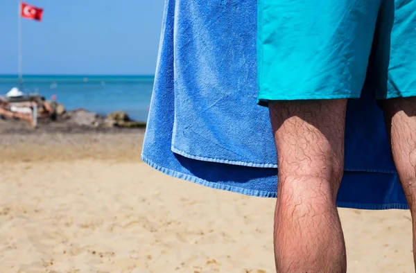 度假村概念 在海上背景下 男性腿上有沙滩毛巾 — 图库照片