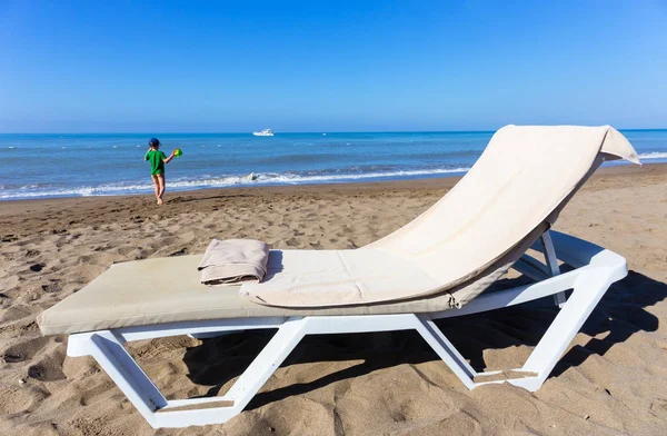 Концепція відпочинку біля моря - шезлонги з пляжним рушником і дитиною — стокове фото