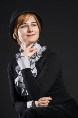 Siyah elbise ve şapka, siyah arka planda stüdyo portre güzel bir genç kadının retro porteit