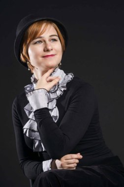 Siyah elbise ve şapka, siyah arka planda stüdyo portre güzel bir genç kadının retro porteit