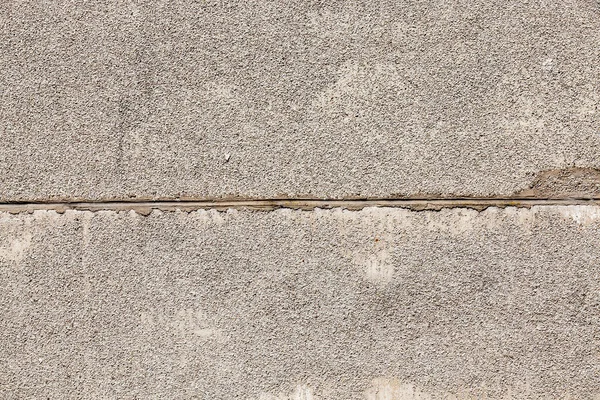 connected together two concrete slabs of the building wall. On the surface of the plates small gravel is fixed to protect against environmental factors. photo close-up.