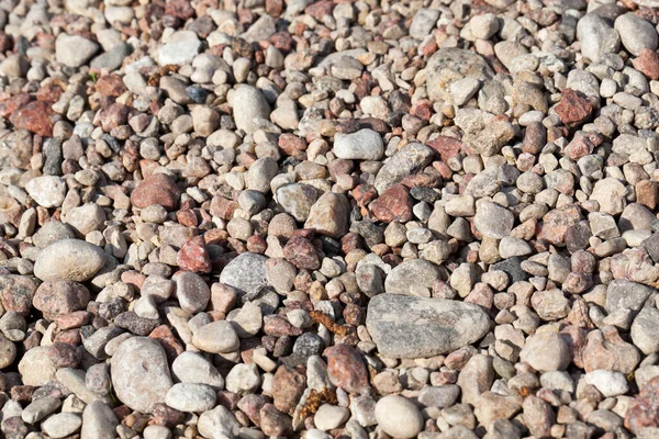 Small and large stones lying on the edge of the road as on the roadside, close-up