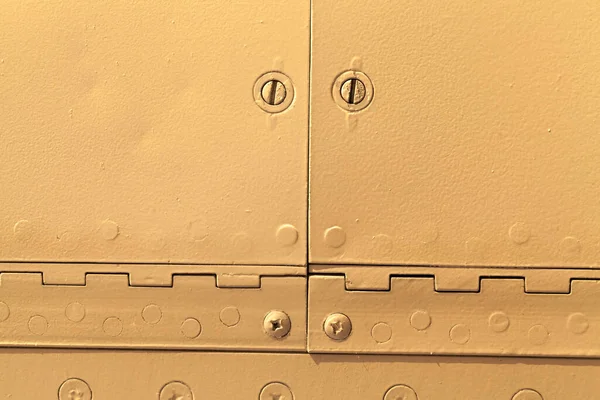 orange metal sheet connected by rivets, close-up of a part of the aircraft