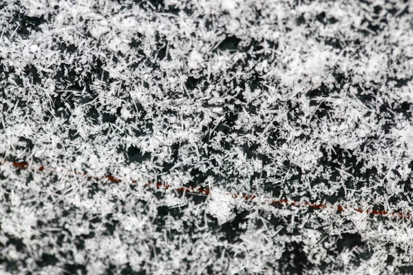 thick layer of snow and snowflakes adhered to the rear window of the car. Photo with a shallow depth of field