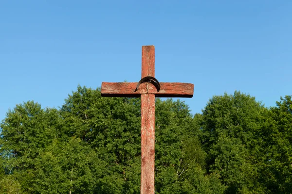 old wooden cross, installed near the highway, a Christian cross cracked paint