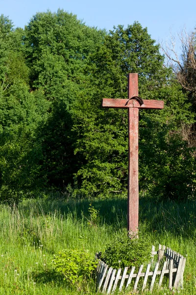 old wooden cross, installed near the highway, a Christian cross cracked paint