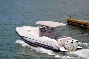 Gri motorlu tekne tuval gölgelik iki kıçtan takmalı motorlar kapalı Miami Beach florida içi kıyı suyolu seyir tarafından desteklenmektedir.