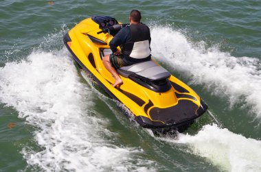 Florida Intra-coastal suyolu parlak sarı jet ski üzerinde seyir bir adamın açılı havai görünümü.