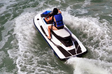 Genç bir kadın beyaz bir jet ski Florida içi kıyı suyolu Miami Beach kapalı sürme açılı havai görünümü.