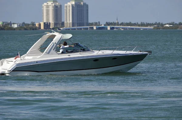 银白色的高端摩托艇在佛罗里达沿海内航道上巡航 背景是迈阿密北部的公寓和吊桥 — 图库照片