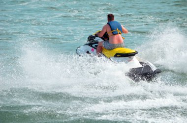 Genç yaşlı çocuk sarı koltuk lu beyaz bir jet ski sürme.