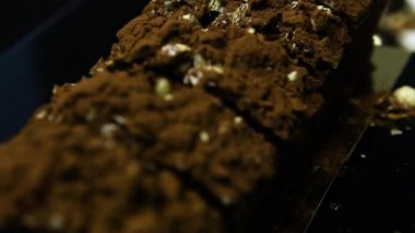 closeup panorama kesilerek lezzetli çikolata tatlı üzerinde ezilmiş fıstık ve çikolata tozu ile dekore edilmiş