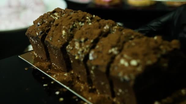 Кондитерська Рука Нарізається Шматочками Домашнього Шоколадного Десерту Прикрашеного Подрібненим Арахісом — стокове відео