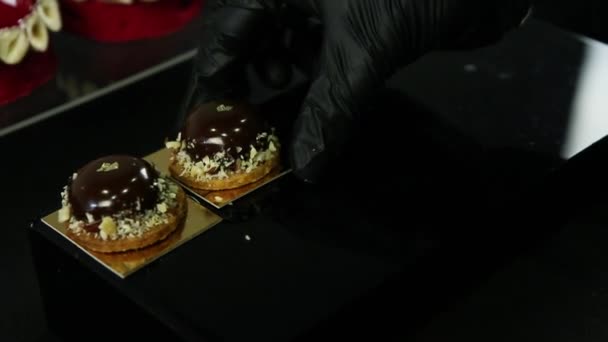 Mão Confeiteiros Coloca Muitas Pequenas Sobremesas Redondas Chocolate Mesa Preta — Vídeo de Stock