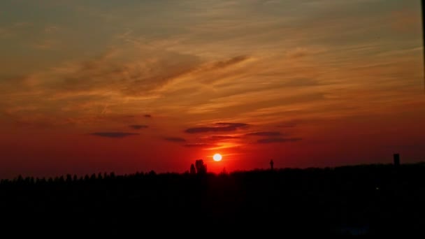 Kleine rode zon slag tegen rode lucht in de stad landschap — Stockvideo