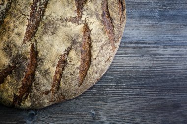 makro büyük tamamen el yapımı yuvarlak siyah ekmek ile ilginç doku yalan üzerine koyu ahşap masa