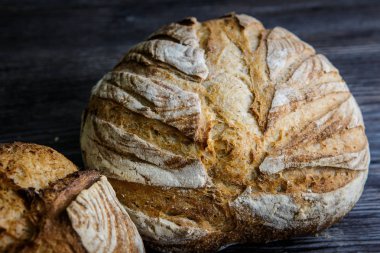 closeup lezzetli tamamen el yapımı yuvarlak beyaz buğday ekmek yalan üzerinde koyu ahşap masa