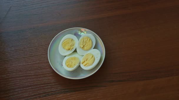 妇女手拿走在褐色木桌小板材与四半煮沸的蛋 — 图库视频影像