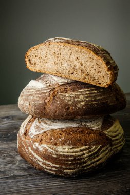 çavdar ekmeği dikey gri arka plan üzerinde closeup üç adet lezzetli ev yapımı yuvarlak