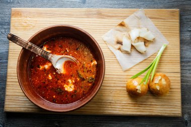 üstten görünüm sarımsak tepesi ile pişmiş halka yanında geleneksel Ukrayna Pancar çorbası ile ahşap plaka üzerinde yeşil soğan ile dekore edilmiş ve donyağı dilimlenmiş