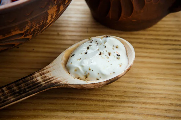 特写木勺与白色酸奶奶油旁边的传统乌克兰粘土菜肴 — 图库照片