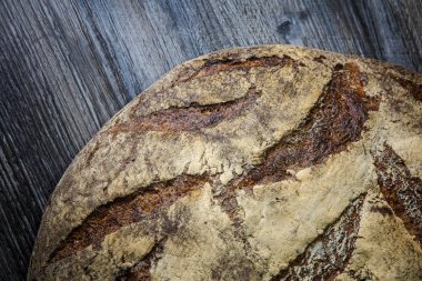 büyük tamamen el yapımı yuvarlak siyah ekmek üzerinde koyu ahşap masa ilginç doku yalanla