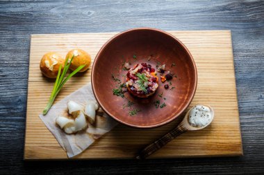 üstten görünüm geleneksel Ukrayna plaka salata sarımsak tepesi ile pişmiş halka yanındaki yeşil soğan ile dekore edilmiş ve donyağı dilimlenmiş