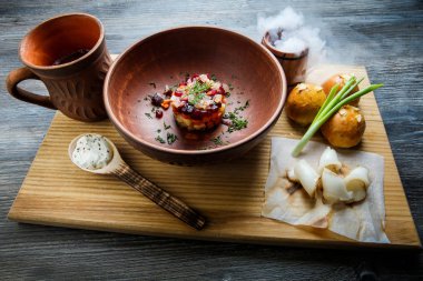 geleneksel Ukrayna plaka salata sarımsak tepesi ile pişmiş halka yanındaki yeşil soğan ile dekore edilmiş ve donyağı ahşap plaka üzerine dilimlenmiş