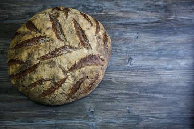 büyük tamamen el yapımı yuvarlak siyah ekmek üzerinde koyu ahşap masa ilginç doku yalanla
