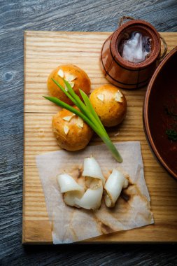 dikey geleneksel Ukrayna pişmiş halka sarımsak tepesi ile yeşil soğan ile dekore edilmiş ve donyağı ahşap plaka üzerine dilimlenmiş