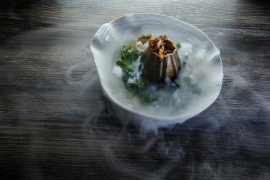 üstten görünüm üzerinde tatlı taze nane ve ahşap masa arka plan üzerinde restoran plaka üzerinde duman süslenmiş kabak servis