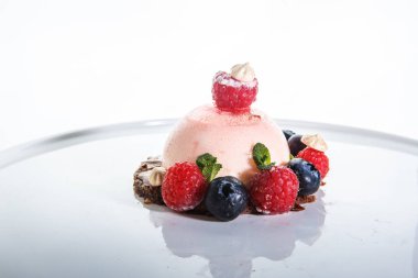 pembe tatlı taze ahududu ve beyaz arka plan beyaz plaka üzerinde yaban mersini ile kaplı