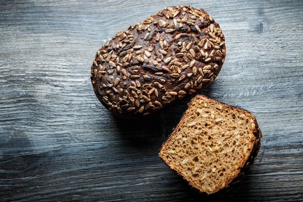 top view of whole and half of handmade delicious handmade rectangular rye bread with sunflower seeds