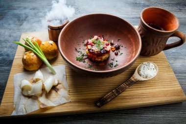 geleneksel Ukrayna plaka salata sarımsak tepesi ile pişmiş halka yanındaki yeşil soğan ile dekore edilmiş ve donyağı ahşap plaka üzerine dilimlenmiş