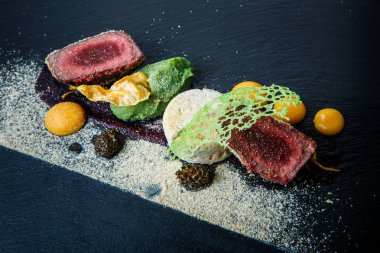 kavrulmuş et ile dekore edilmiş iki adet portre püre ve siyah plaka restoran ahşap tablo üzerinde sos