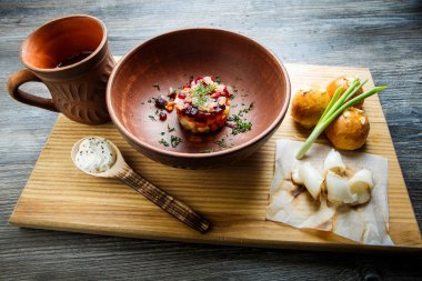 geleneksel Ukrayna plaka salata sarımsak tepesi ile pişmiş halka yanındaki yeşil soğan ile dekore edilmiş ve donyağı ahşap plaka üzerine dilimlenmiş