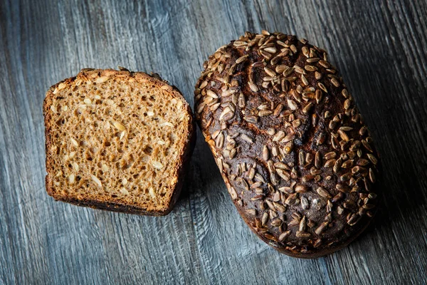 top view of whole and half of delicious homemade rectangular rye bread with sunflower seeds